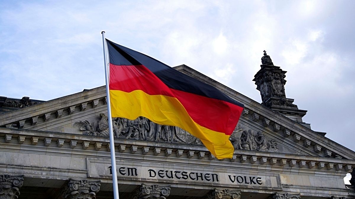 Bandera de Alemania sobre el fondo del Parlamento Alemán Bandera de Alemania sobre el fondo del Parlamento Alemán