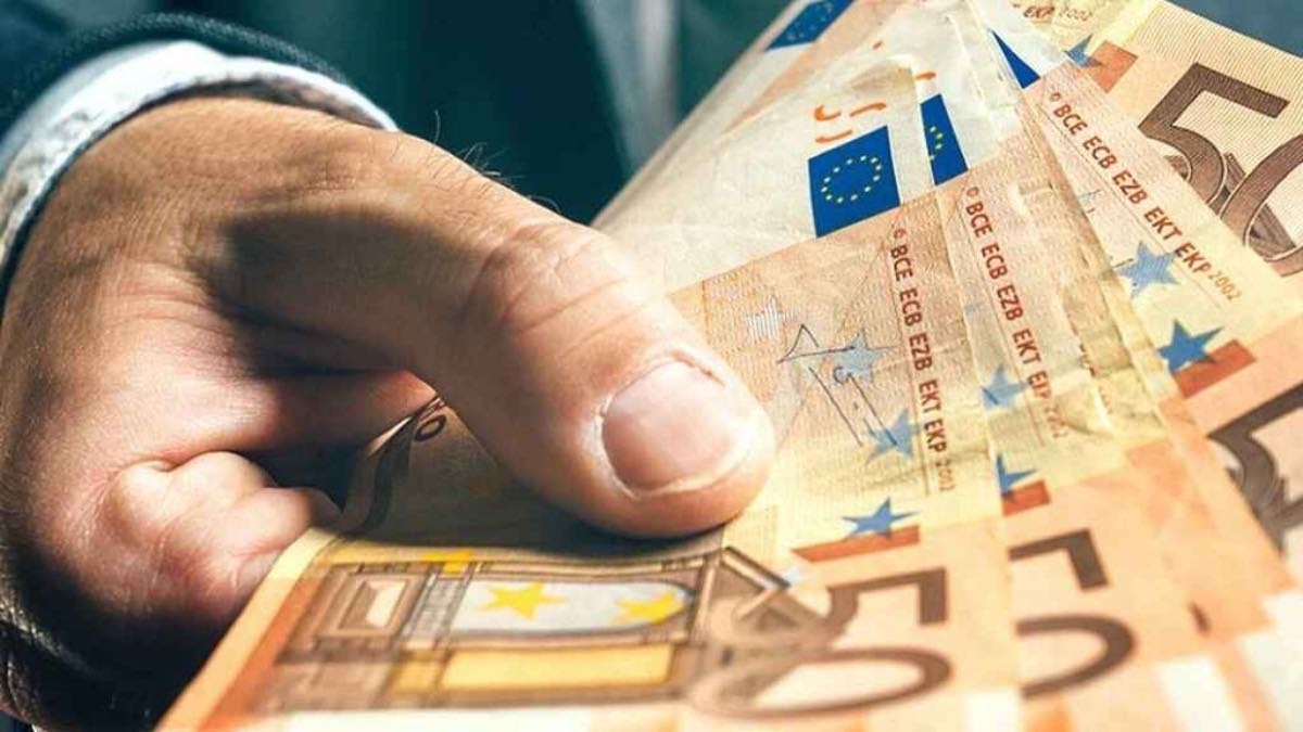 una persona sostiene billetes de 50 euros en la mano