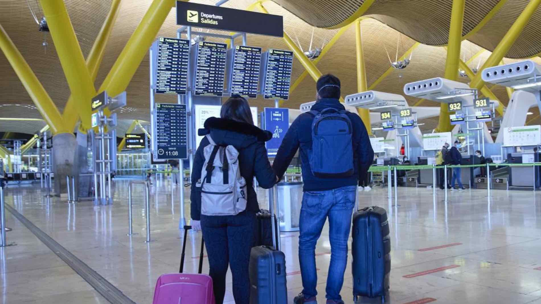 personas buscando su viaje en un panel de vuelos