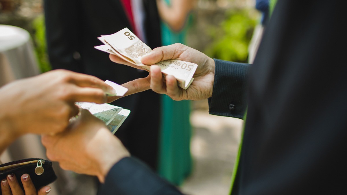 Una persona pagando a otra su salario