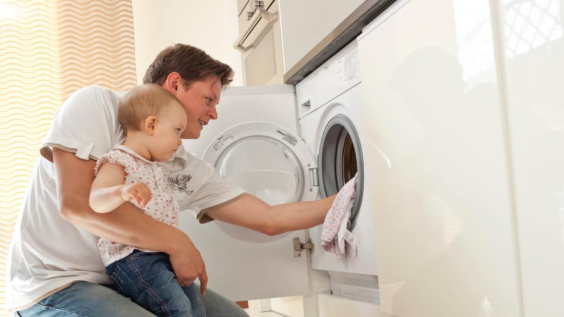 padre pone con su hijo la lavadora