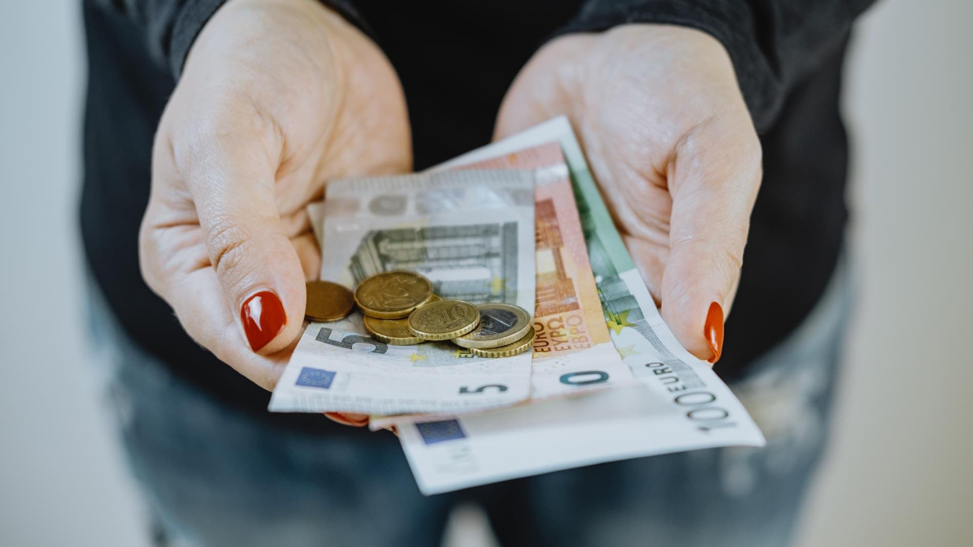 Beneficiario del IMV con euros en la mano