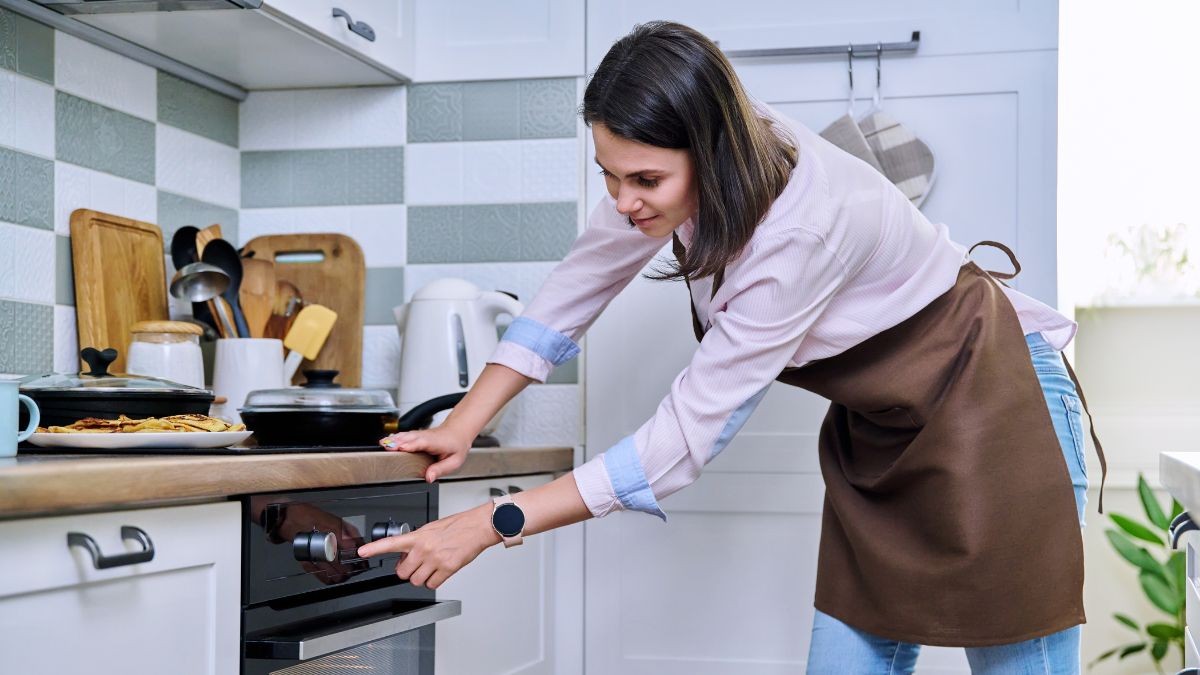 Precio de la luz viernes, 7 de abril de 2023 una mujer pone en funcionamiento el horno