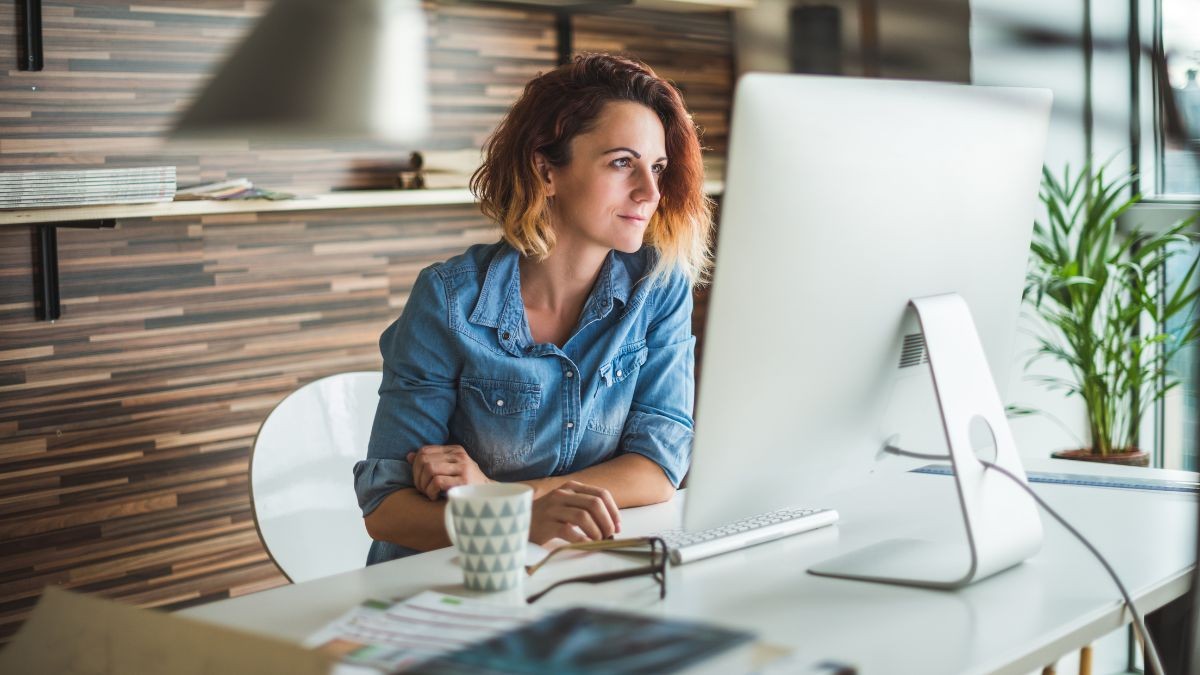 Cómo crear un currículum con Canva gratis paso a paso Mujer creando su CV en Canva en su ordenador