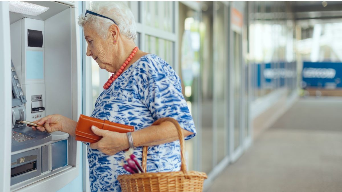 persona mayor retirando dinero del cajero automático