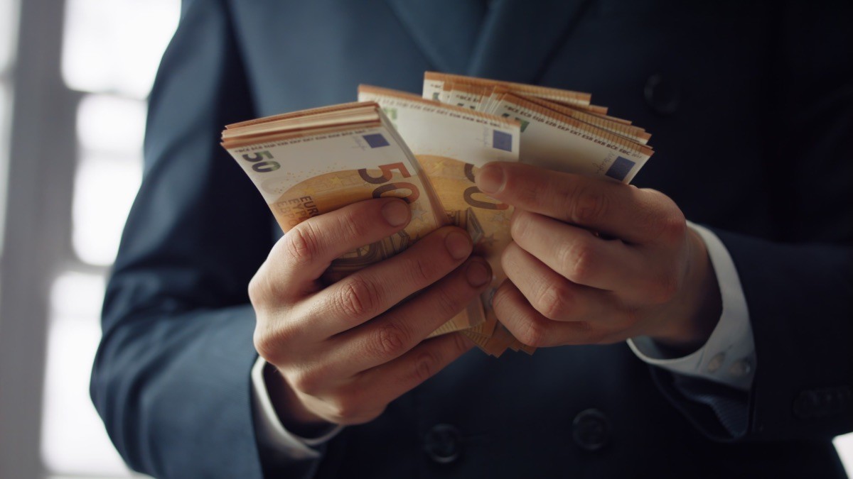 Hacienda destaca el aumento de salarios en las grandes empresas y pymes en el segundo trimestre de 2023 empleado contando euros