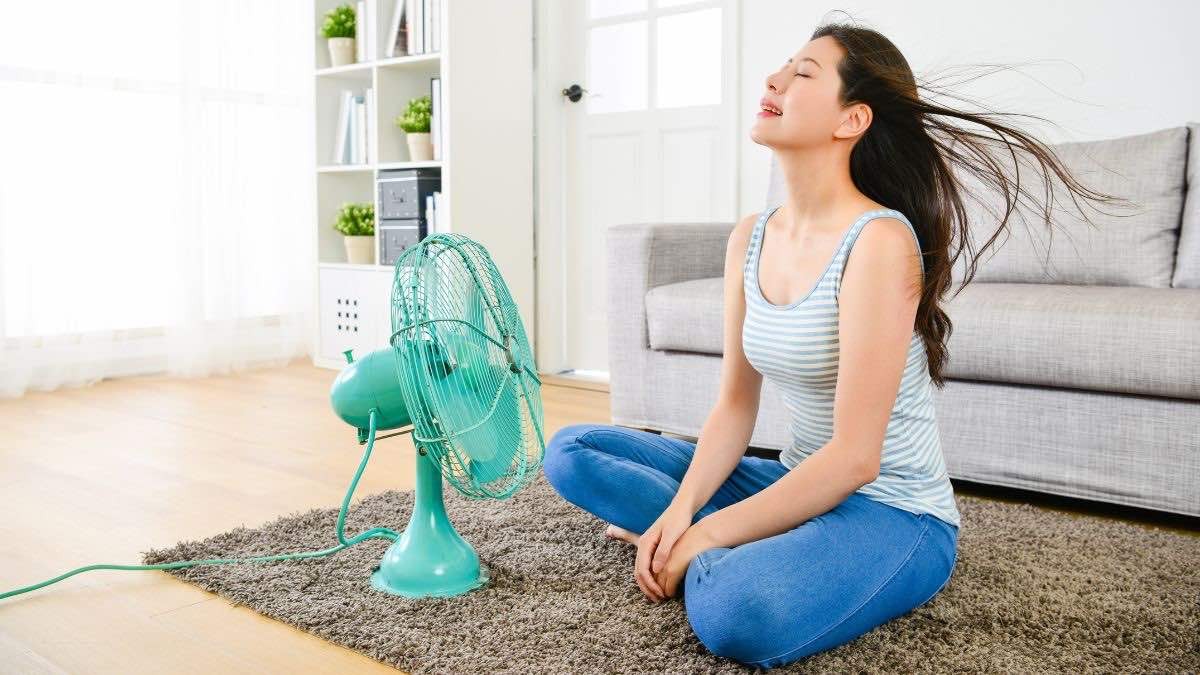 mujer refrescándose con un ventilador