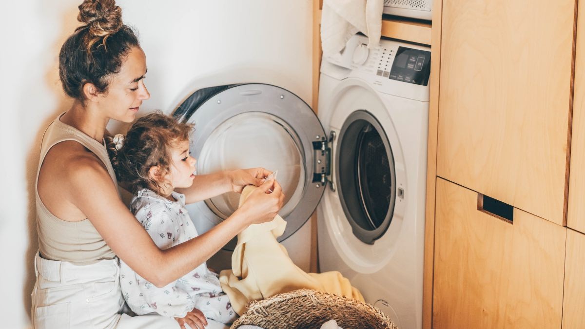 Precio de la luz del martes, 15 de agosto de 2023 Una madre pone la lavadora con su hija