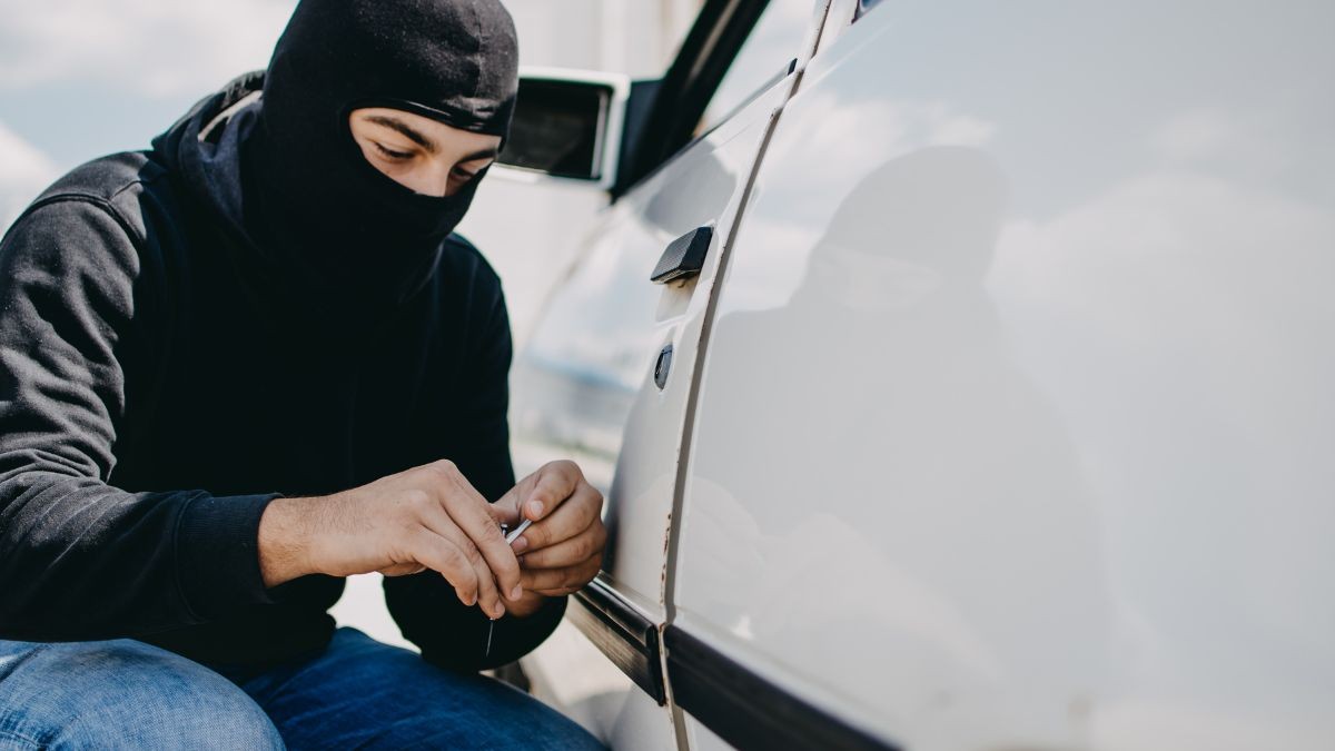 Un hombre intenta robar el catalizador de un coche Hombre robando el catalizador de un coche