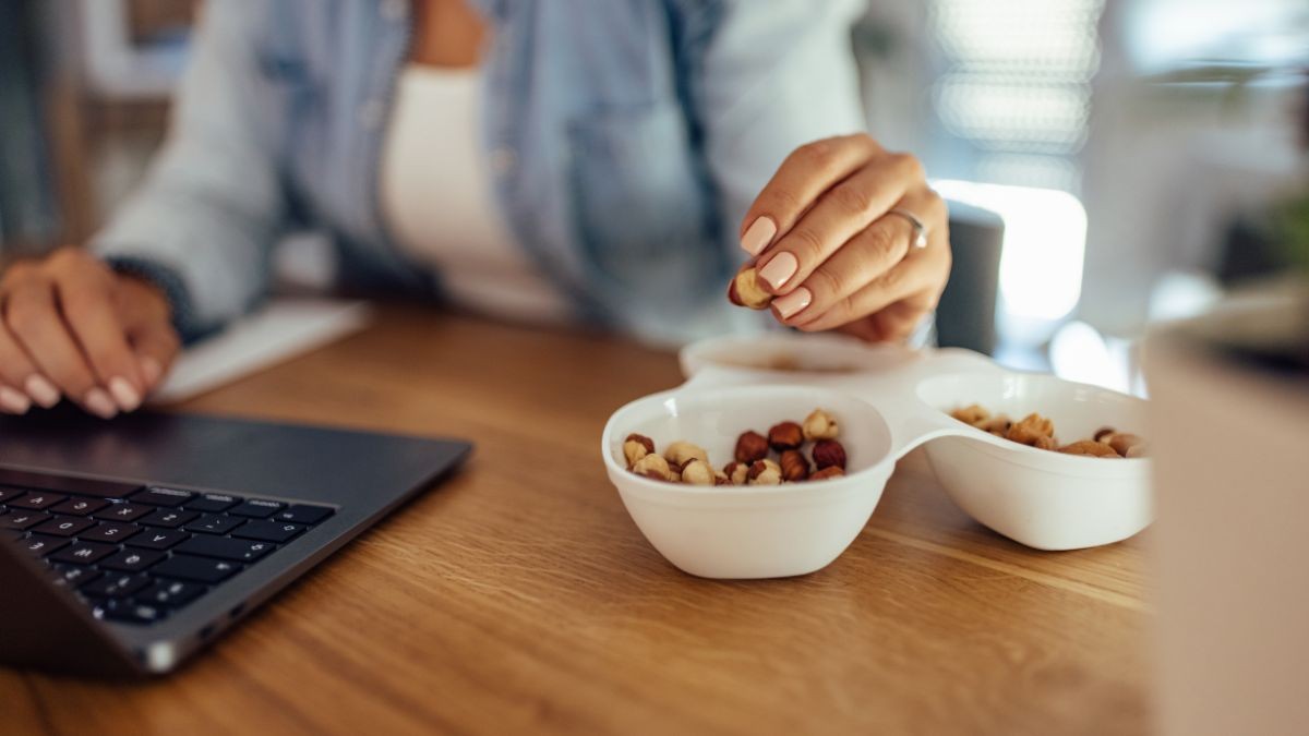 Mujer comiéndose un snack mientras trabaja