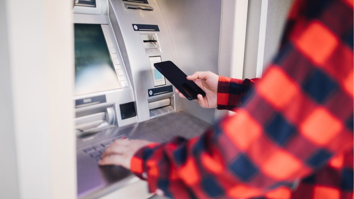 Un usuario emplea un teléfono móvil para sacar dinero. La aplicación que necesitas para sacar dinero del cajero automático sin tarjeta