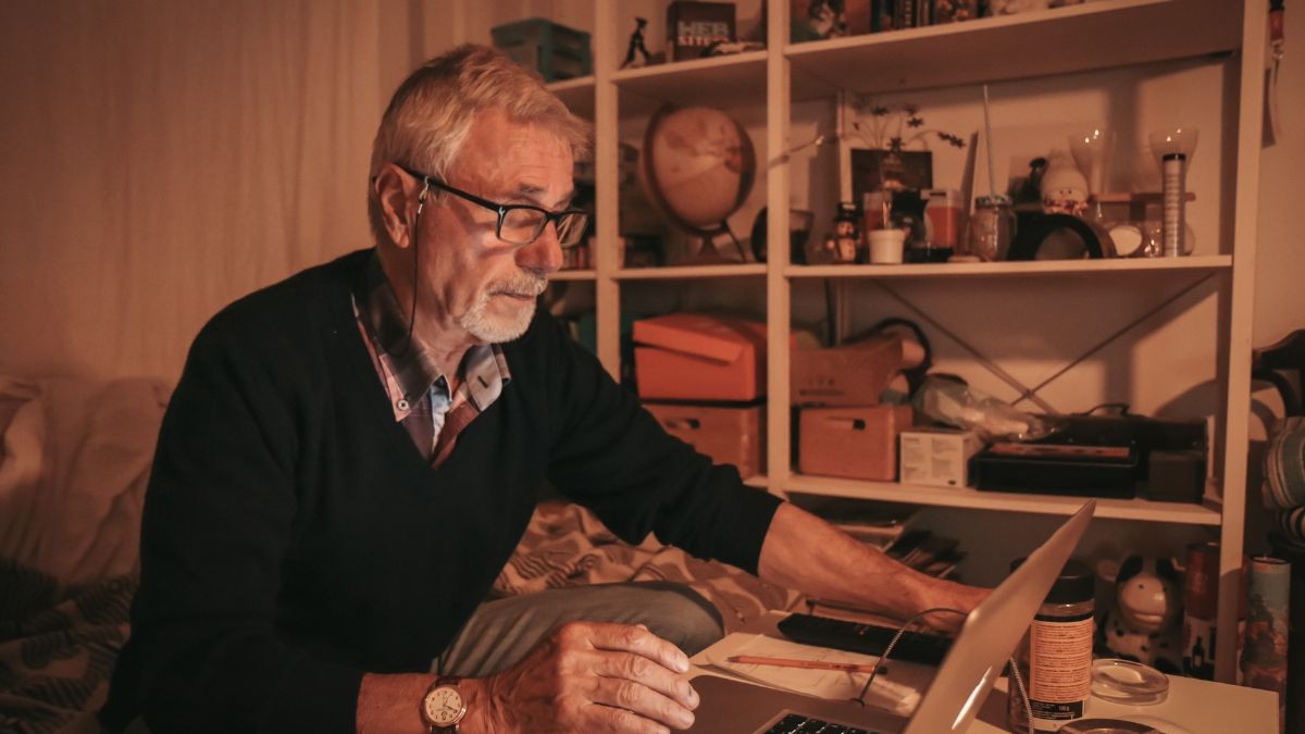 Cómo conseguir el Bono social de internet que tienen las compañías telefónicas Hombre consultando internet en un ordenador portátil