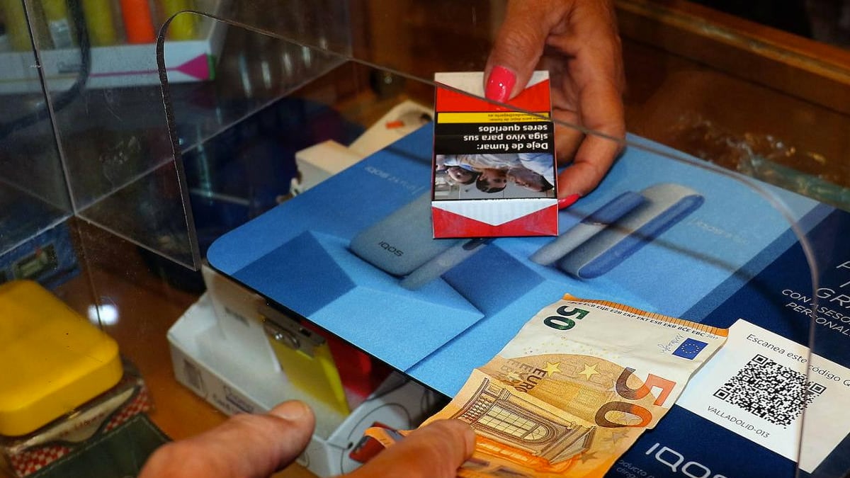 una persona compra una cajetilla de tabaco