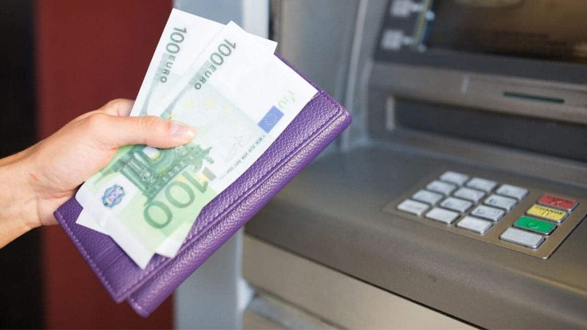 Los mejores bancos que te devuelven dinero al realizar tus compras. manos de una mujer con euros en la mano