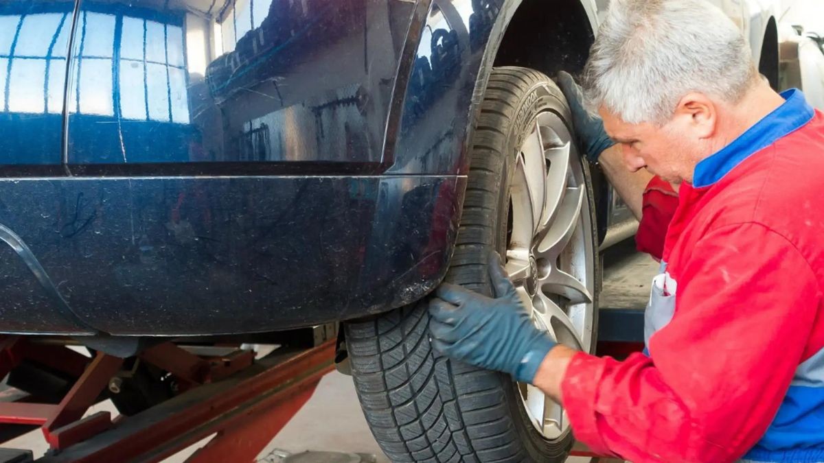 Un mecánico cambia una rueda en el taller.