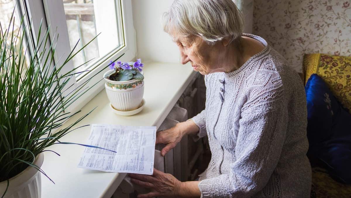 mujer mayor mirando la factura de la luz
