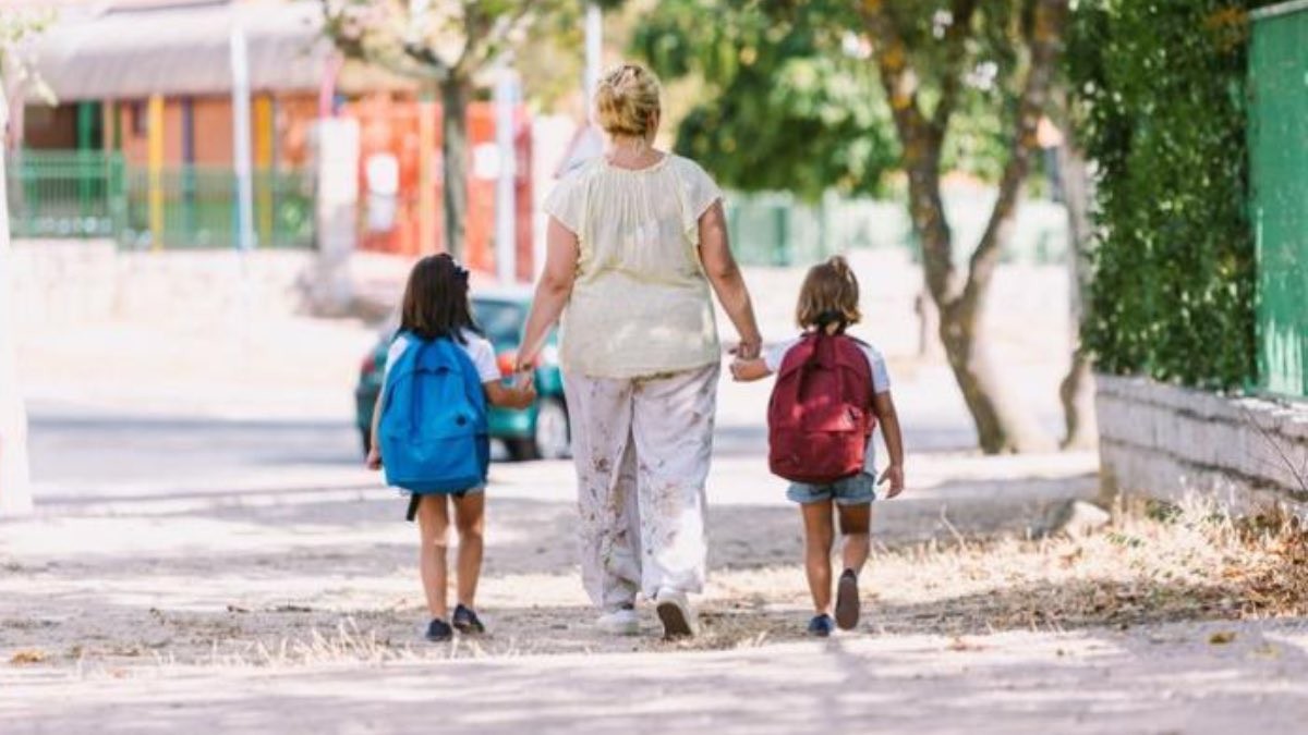 madre caminando con sus hijos de la mano