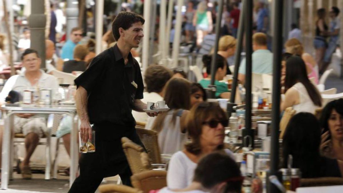 Trabajo con contrato indefinido en Navarra: 185 ofertas de empleo para camareros, profesores... Un camarero atiende en una terraza.