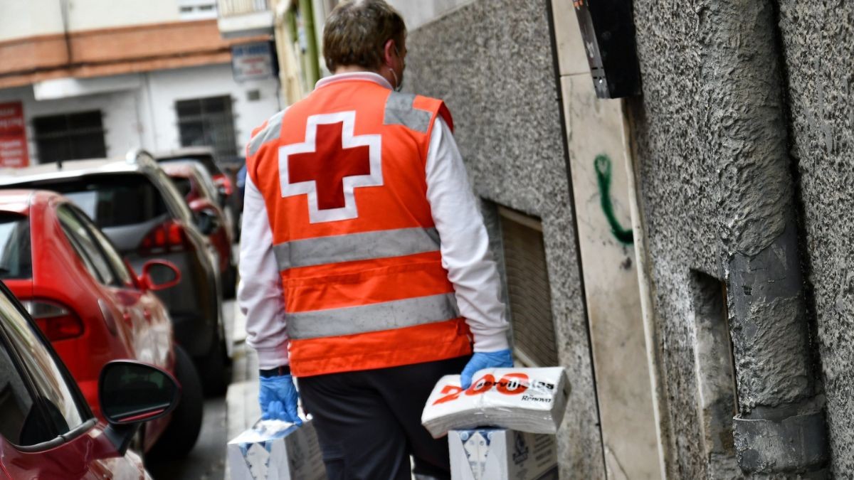Un trabajador de Cruz Roja reparte alimentos.