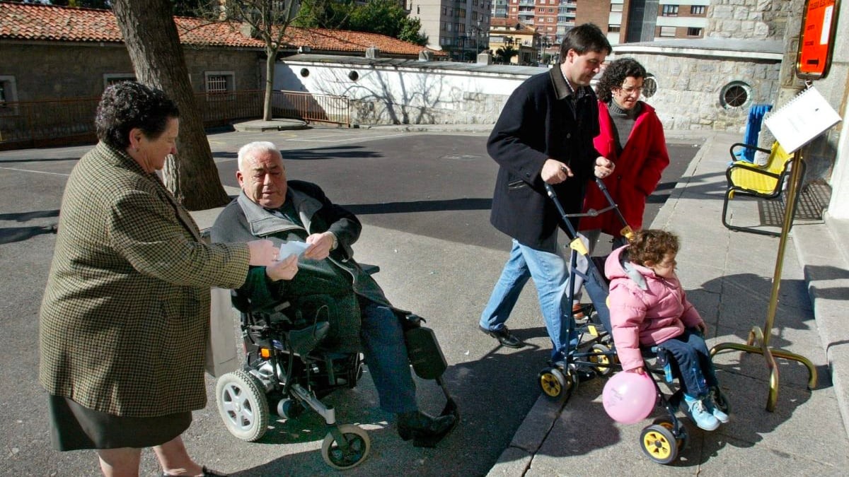 Hacienda ya tiene disponible esta ayuda de 2.400 euros: qué es, requisitos y cómo solicitarla. Un anciano discapacitado con su mujer y una pareja con su bebé