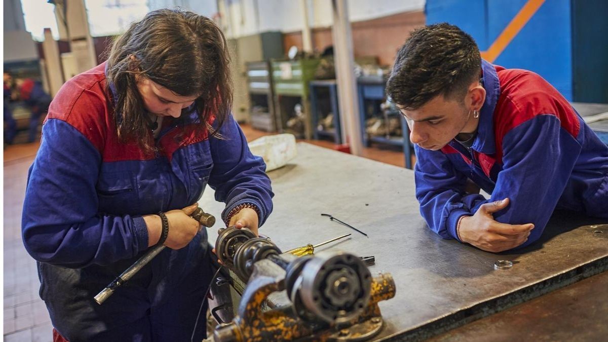 El SEPE publica ofertas de empleo fijo para jóvenes con opción de trabajar en el extranjero Dos jóvenes realizando prácticas en un taller mecánico.
