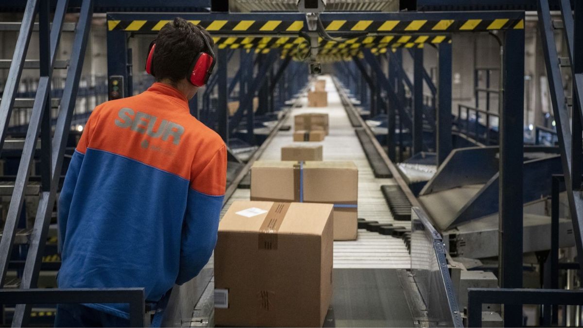 Un trabajador en un almacén de SEUR.