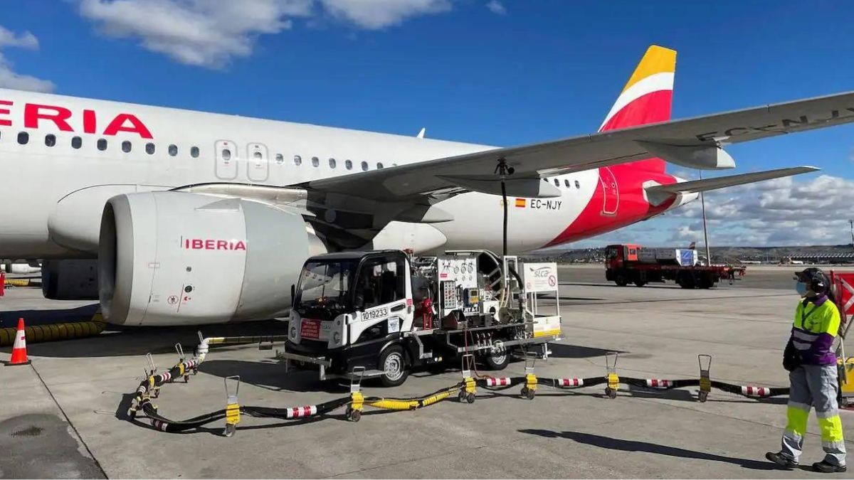 Sueldo de 3.000 euros: se necesitan trabajadores con empleo fijo en aeropuertos Un avión en una pista de aterrizaje con una trabajadora al lado.
