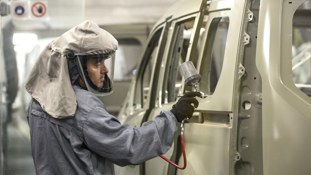 Un trabajador de la fábrica Ford pintando un coche.