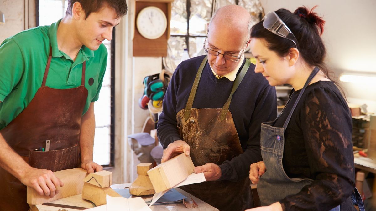 Zapateros trabajando en una horma de zapato.