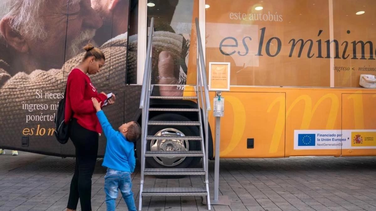 madre migrante con su hijos en la puerta del Ingreso Mínimo Vital