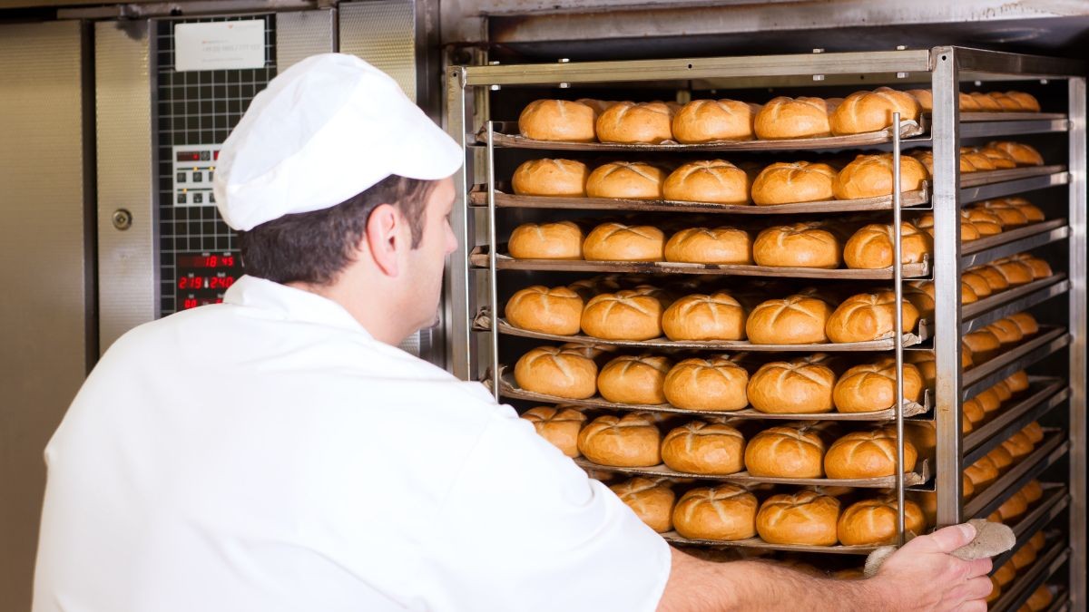 Un panadero horneando pan.