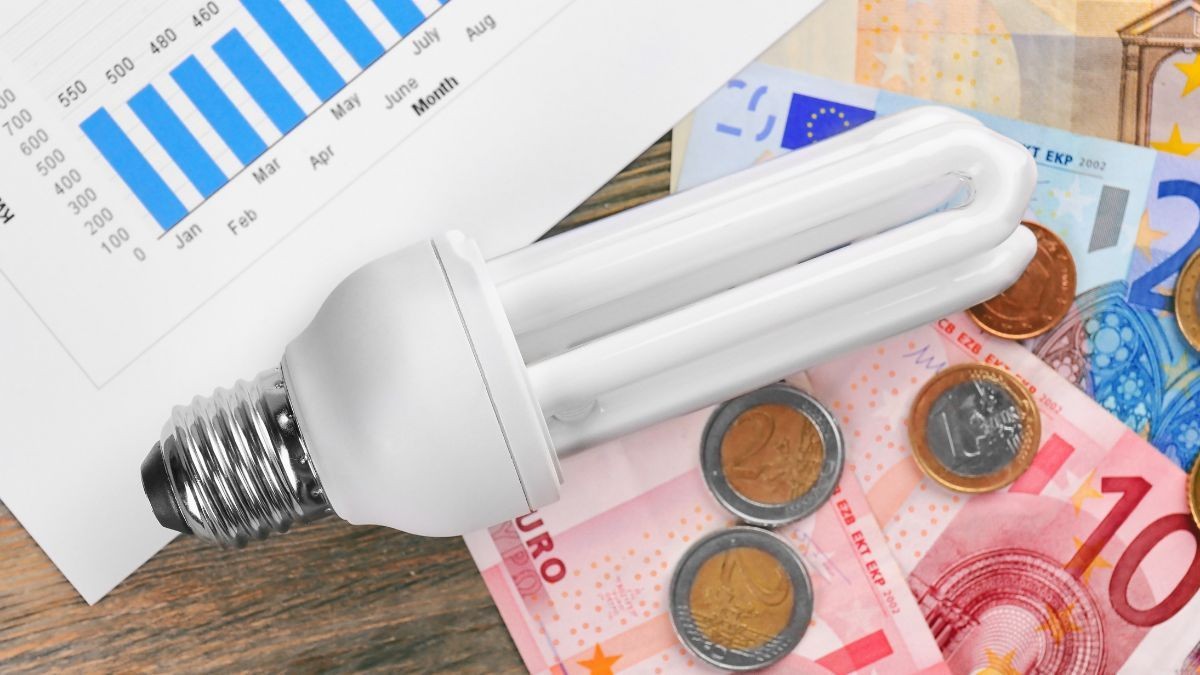 Consulta el precio de la luz para el día de hoy varias bombillas, facturas y monedas de euro