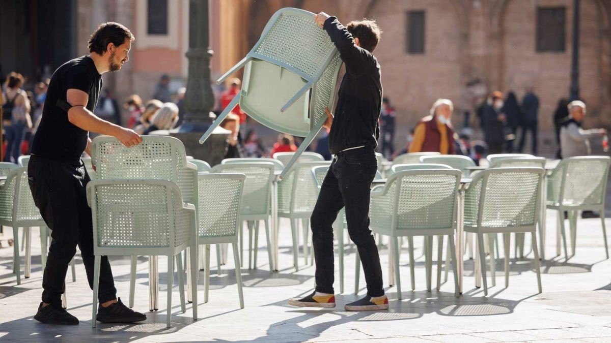 Dos camareros en una terraza.