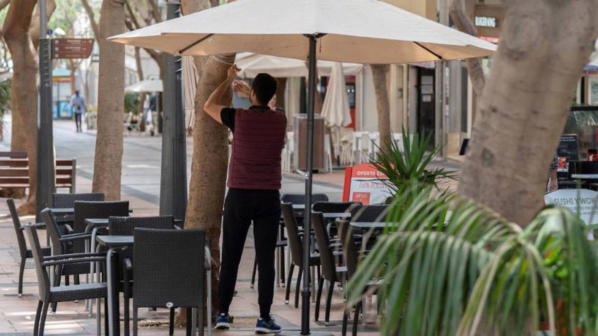Las ofertas de empleo en turismo y restauración crecen con más contratos indefinidos Un camarero coloca una sombrilla en su trabajo.