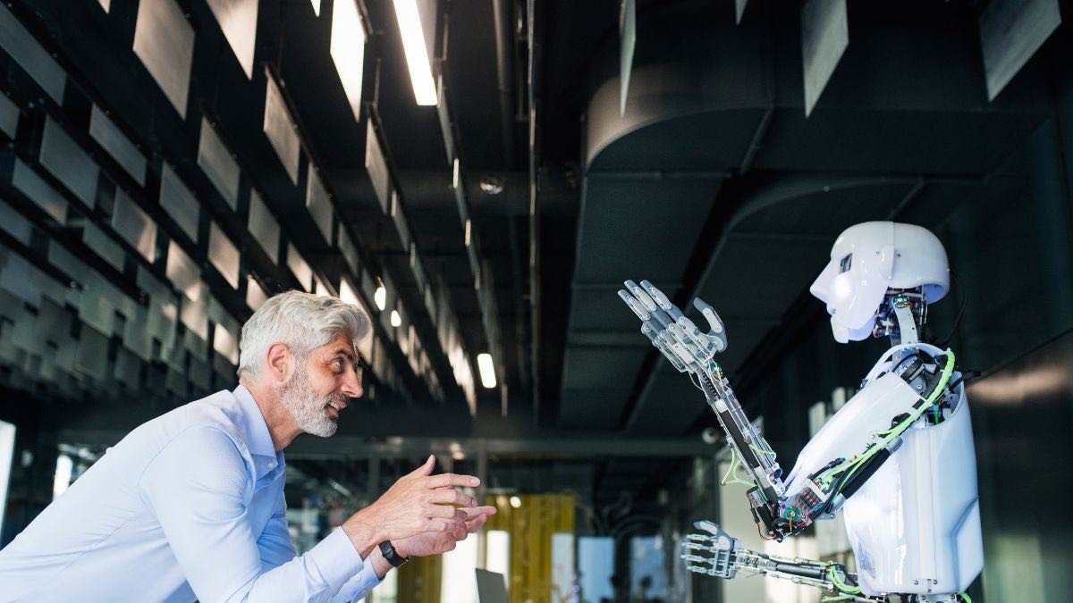 Una persona junto a un robot