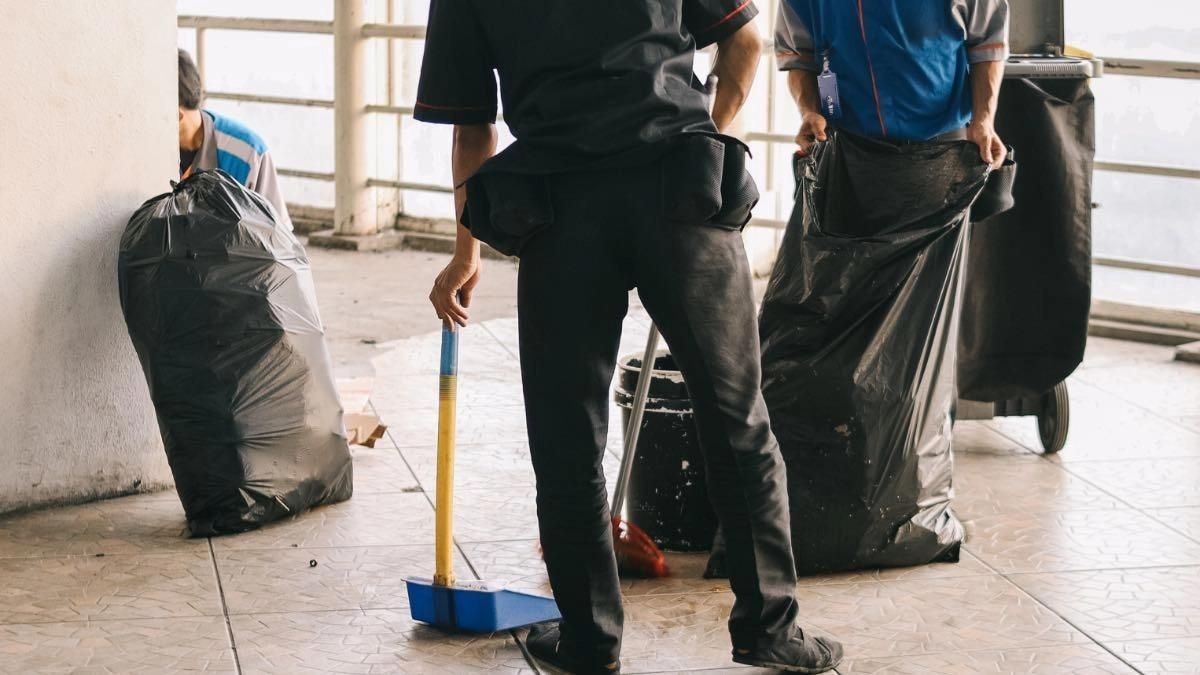 Ofertas de empleo para conserjes Dos conserjes trabajan recogiendo basura en un edificio
