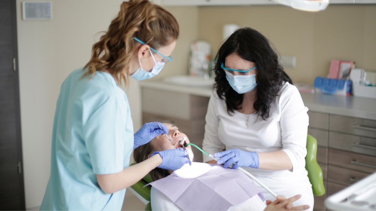 Vitaldent está contratando: estos son los perfiles que busca. Una paciente pasando consulta en una clínica dental.
