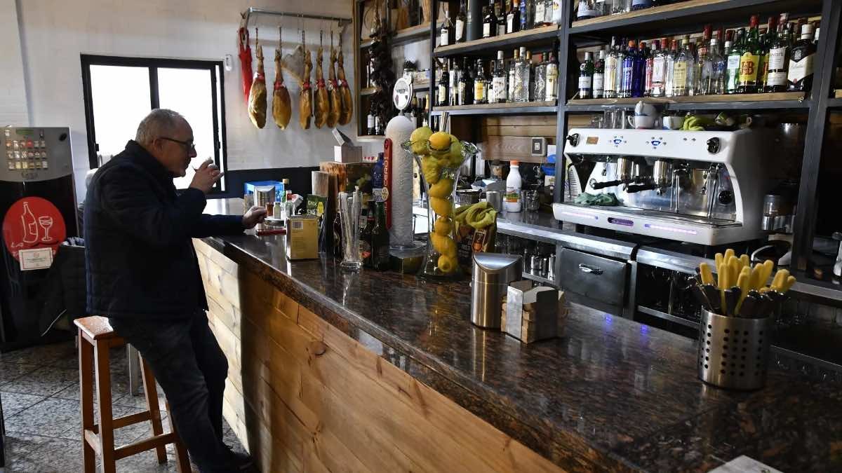 Te sorprenderá conocer la provincia española con más bares de España. Hombre mayor sentado en la barra de un bar español
