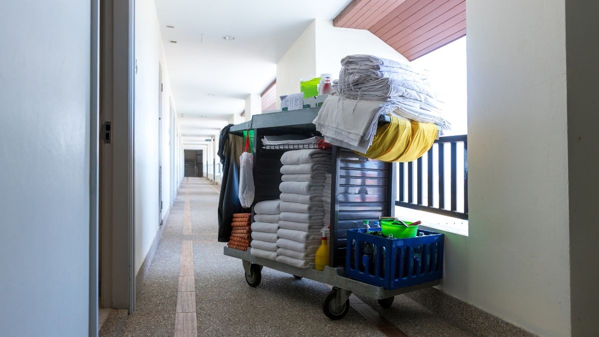 Un carrito de la limpieza aparcado al lado de una puerta en un hotel.
