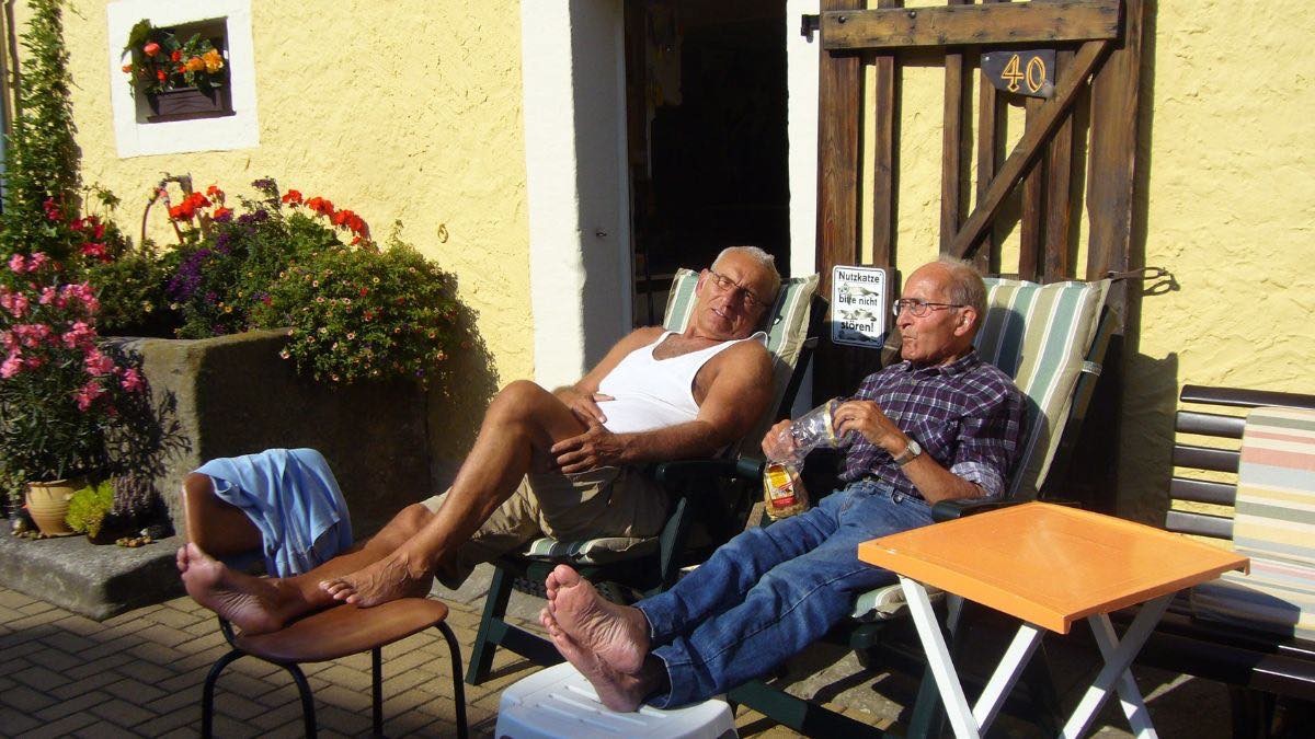 dos jubilados sentados en la puerta de la casa tomando el sol dos jubilados sentados en la puerta de la casa tomando el sol