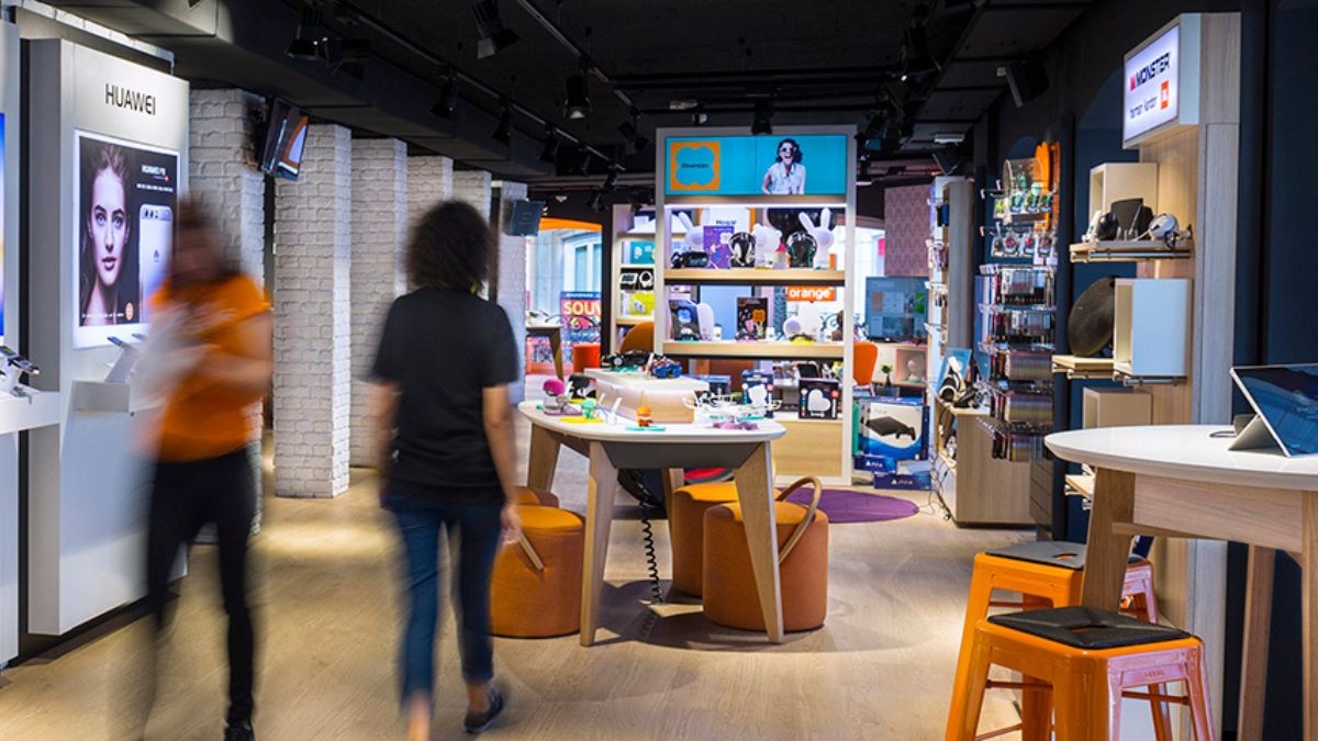 Orange busca personal para trabajar en atención al cliente: no hacen falta estudios superiores. Interior de una tienda de Orange, con empleados.