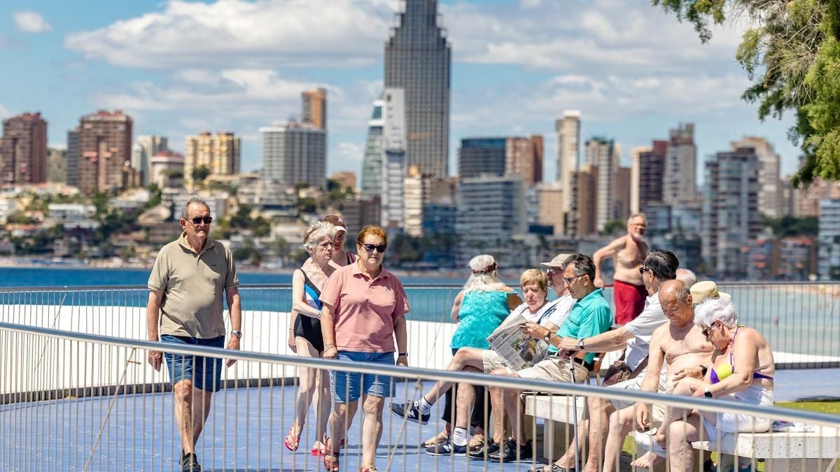 Los viajes del Imserso no tendrán retrasos y este es el motivo. Un grupo de turistas mayores caminando frente a una playa