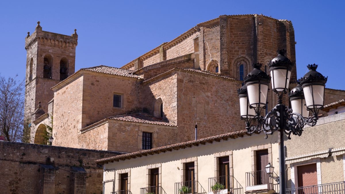 Empleo con casa gratis y sueldo de 1.600 euros: se necesita personal de limpieza. Imagen de una iglesia antigua con casas en Guadalajara.