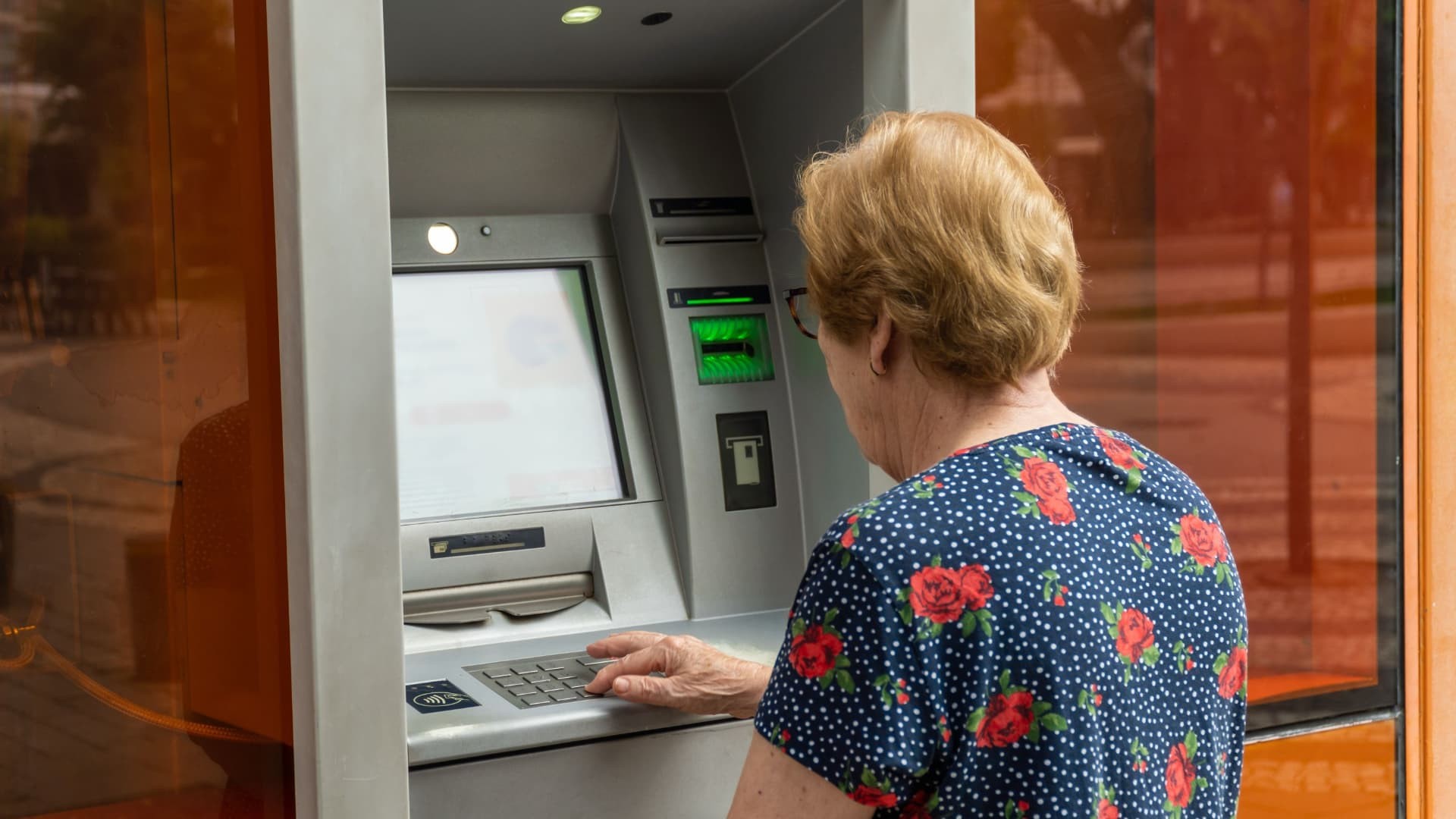 Cuándo se cobran las pensiones en julio de 2024 Una pensionista saca dinero de una cuenta bancaria