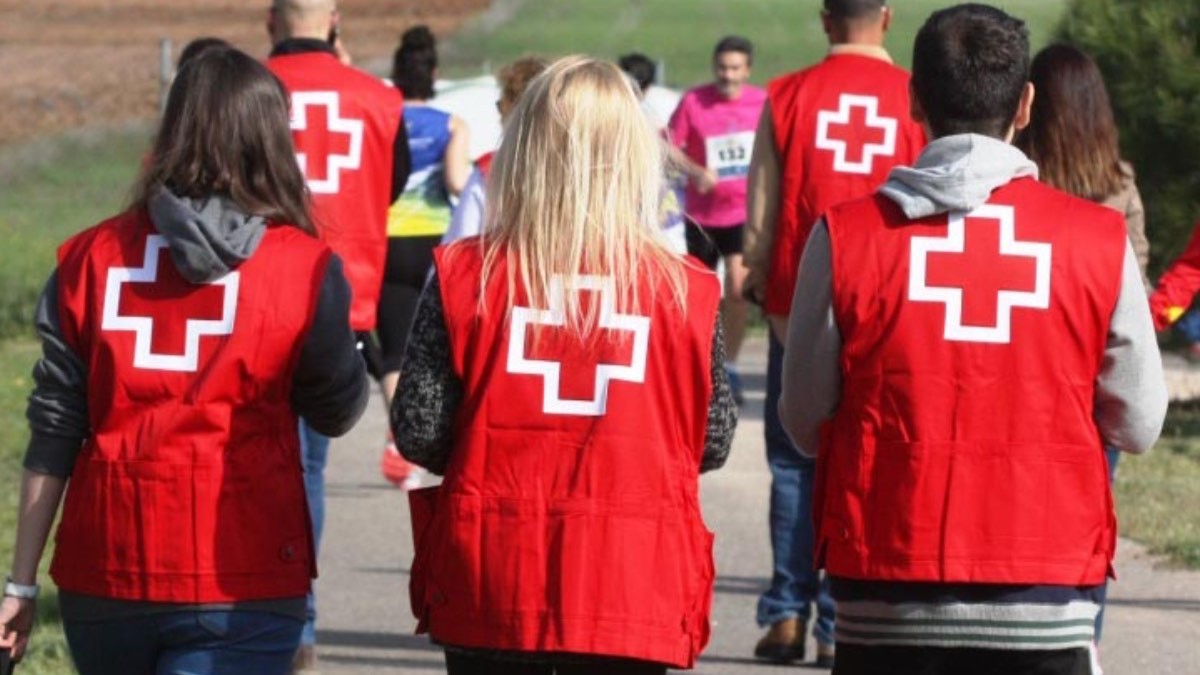 Cruz Roja busca trabajadores de todo tipo: contrato indefinido e incorporación inmediata en la mayoría de ofertas trabajadores de Cruz Roja caminando de espaldas
