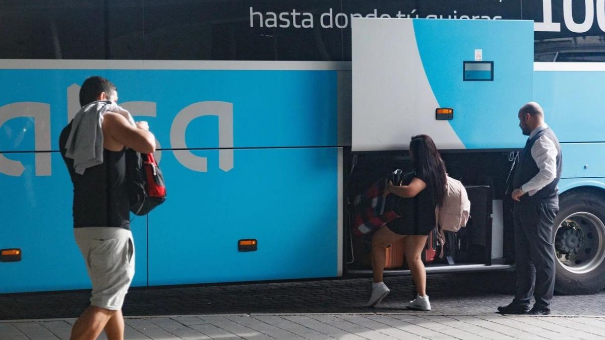 Un conductor de Alsa ayuda a los viajeros a cargar las maletas.