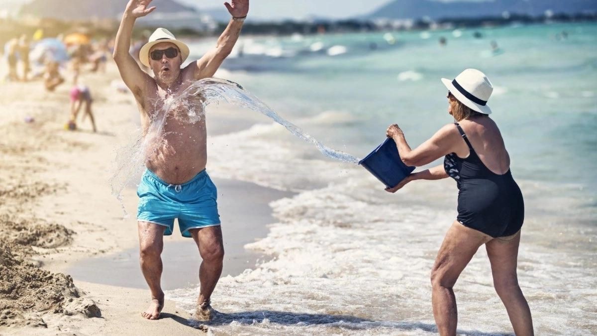 Los viajes del Imserso más económicos: destinos a sólo 200 euros. Dos personas mayores tomando el sol en una playa.