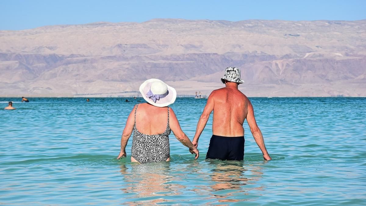 Hoy comienza la venta de los viajes del Imserso con estos requisitos y fechas. Dos personas mayores se bañan en el mar.