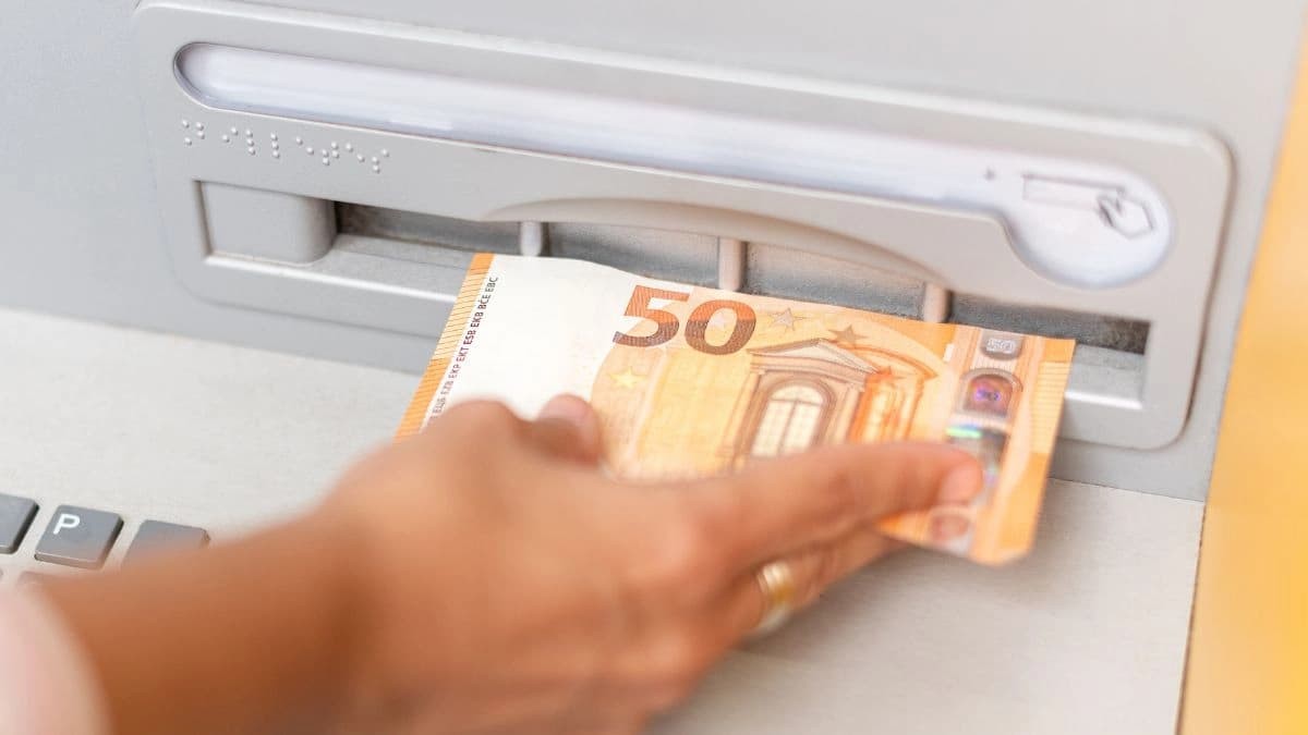 Una mujer sacando el dinero de la pensión de un cajero automático Una mujer sacando el dinero de la pensión de un cajero automático