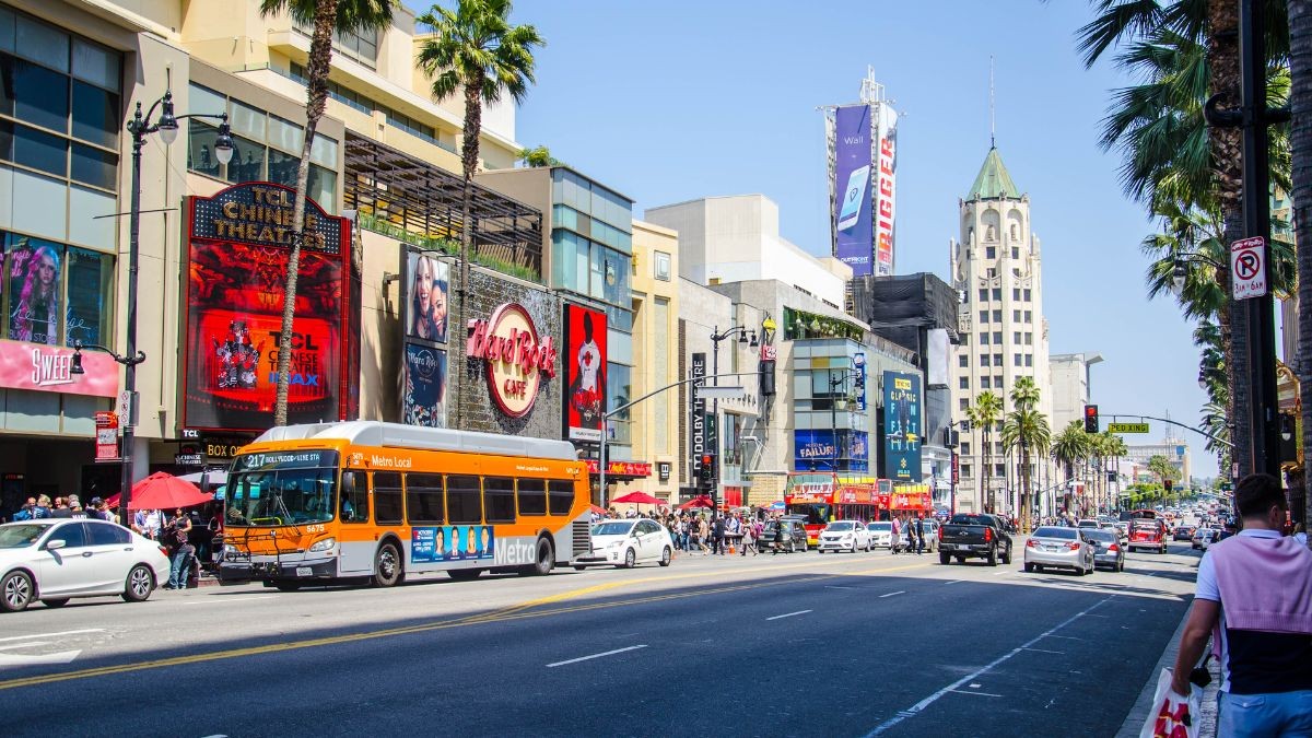 Una calle de California con luminosos y un autobús